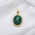 Gold pendant with a green stone on a white background