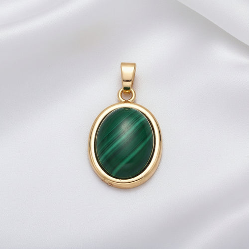 Gold pendant with a green stone on a white background