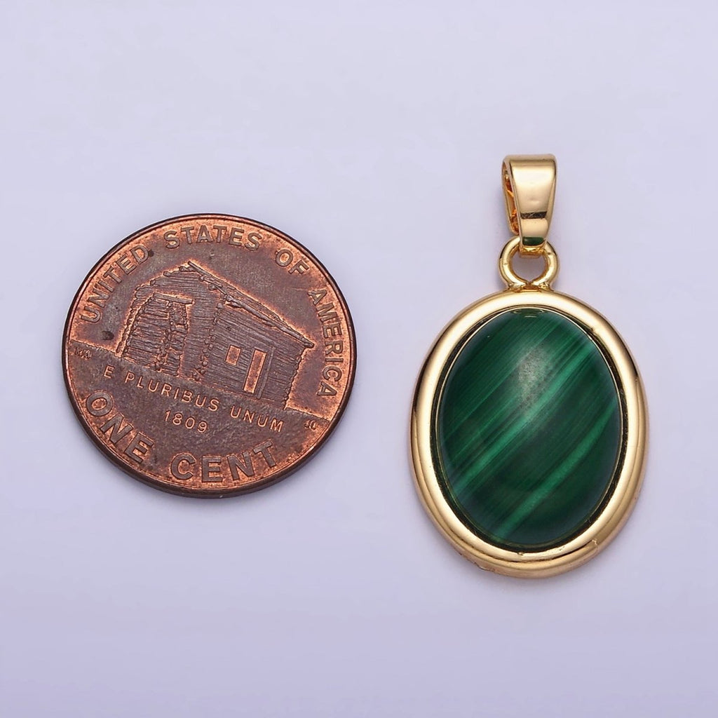 Gold pendant with green stone next to a penny on a light purple background