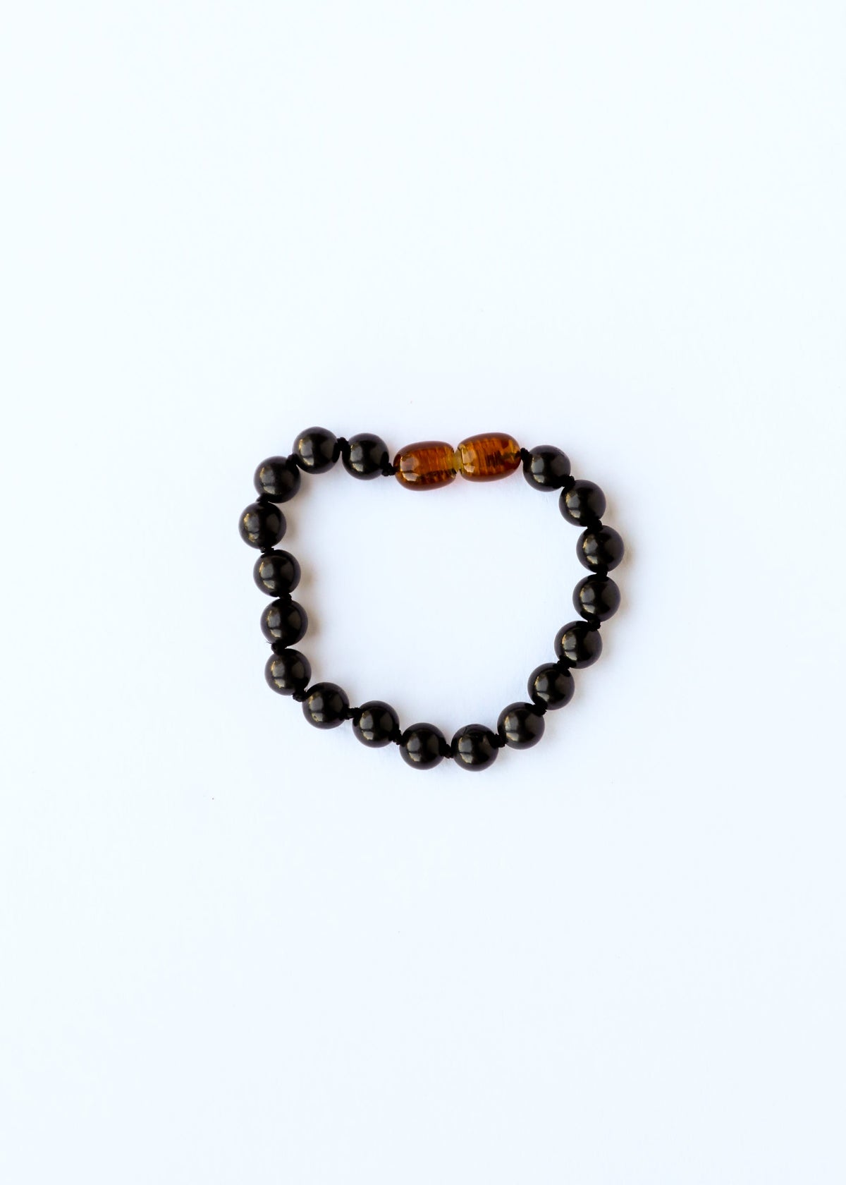 Black beaded bracelet with a single amber bead on a white background