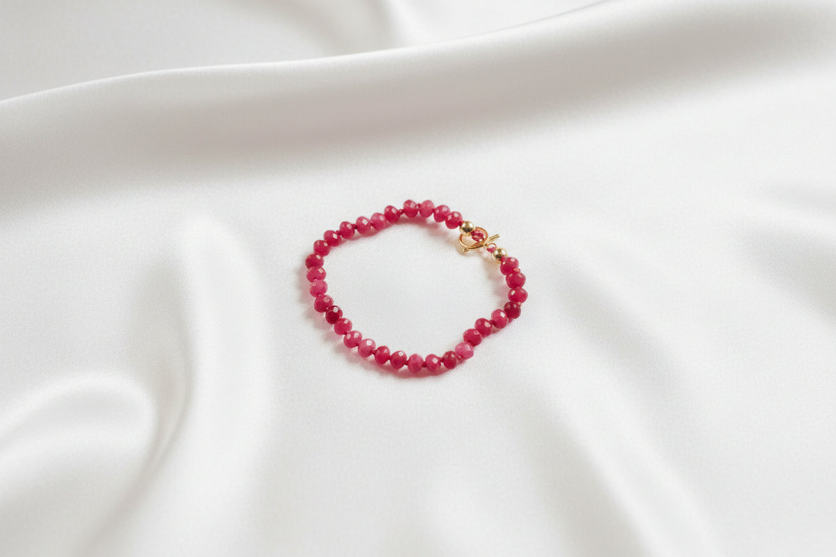 PINK STONE BRACELET ON WHITE SILKY BACKGROUND