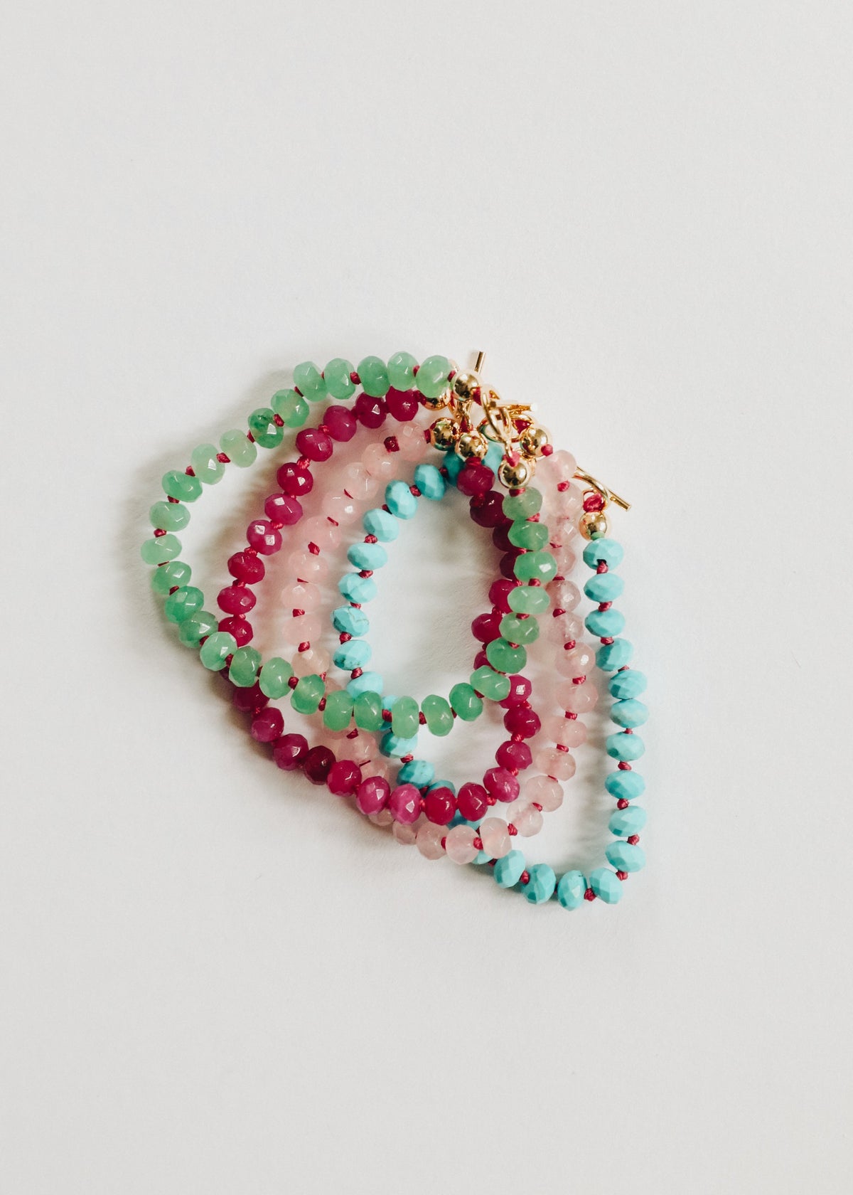 Set of colorful beaded bracelets on a light gray background