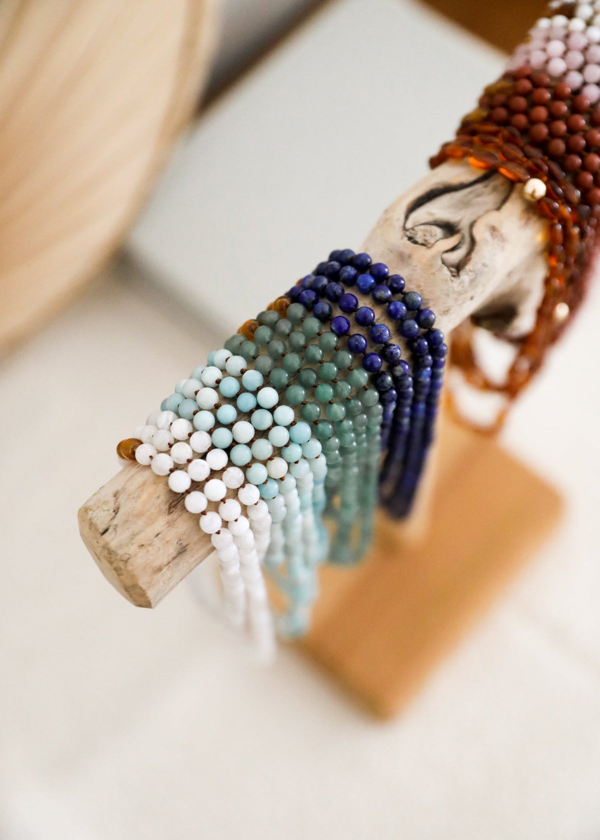 Colorful beaded bracelet on a piece of driftwood with a blurred background