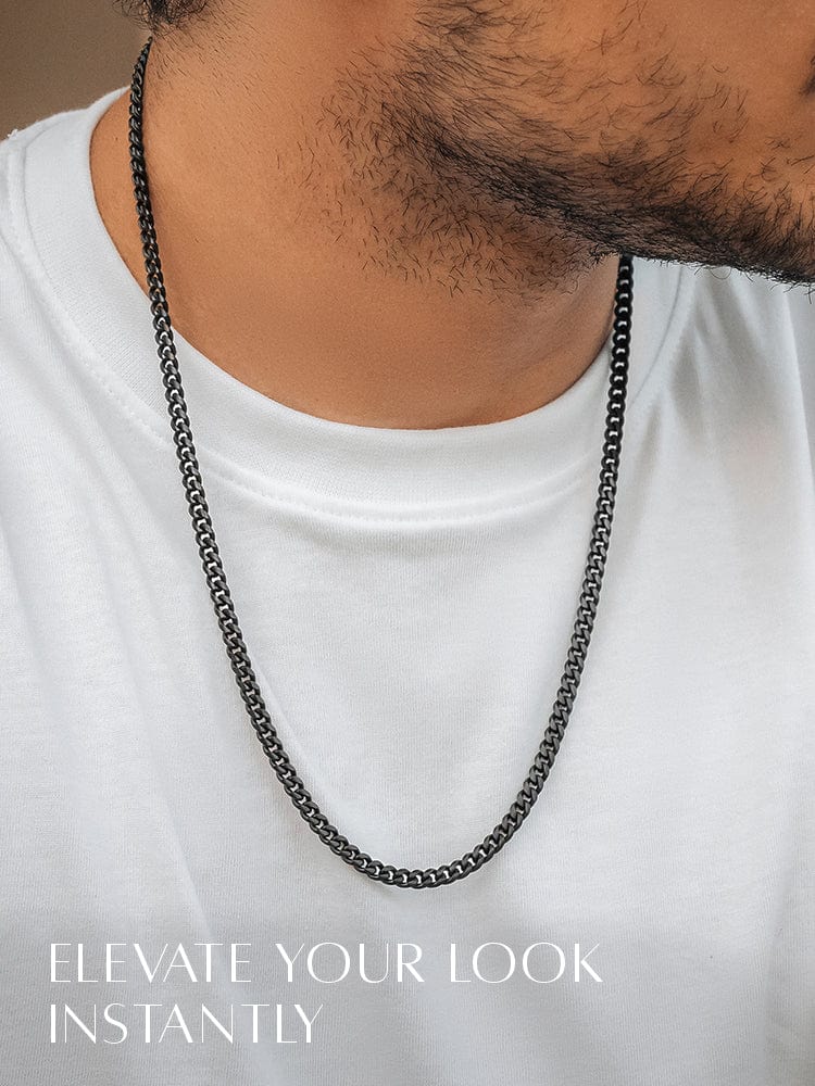Black chain necklace on a person wearing a white shirt with text 'Elevate Your Look Instantly'.