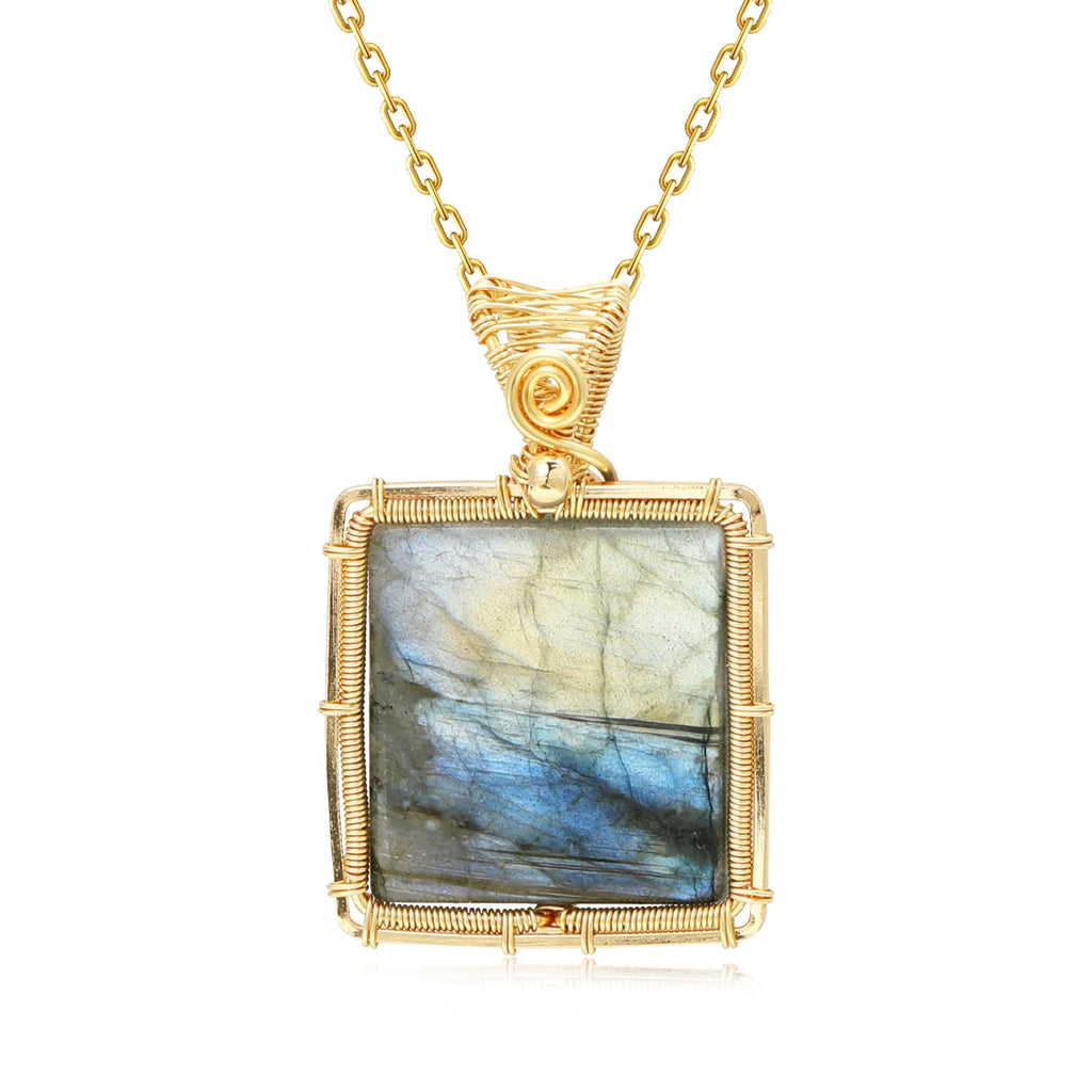 Gold-framed labradorite pendant on a white background