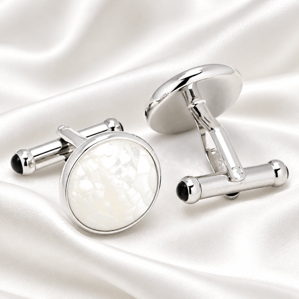 Silver cufflinks with a white circular stone on a white background