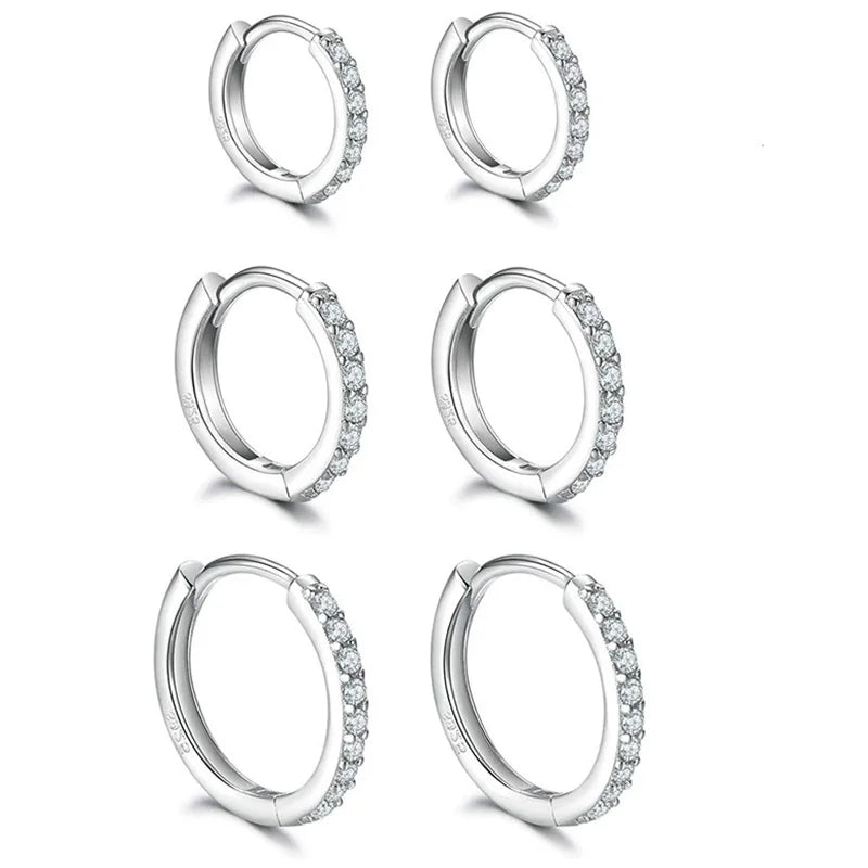 Set of silver hoop earrings with clear stones on a white background