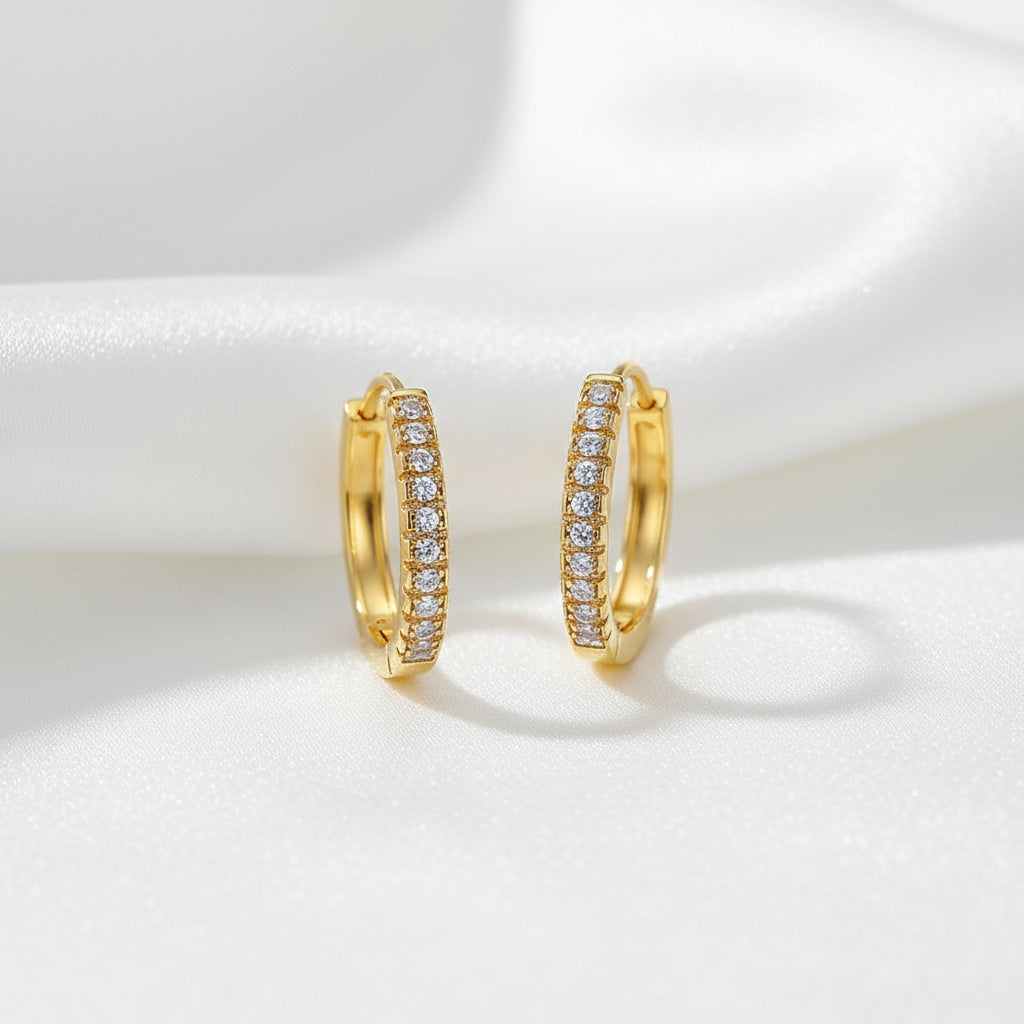 Gold hoop earrings with embedded stones on a white background