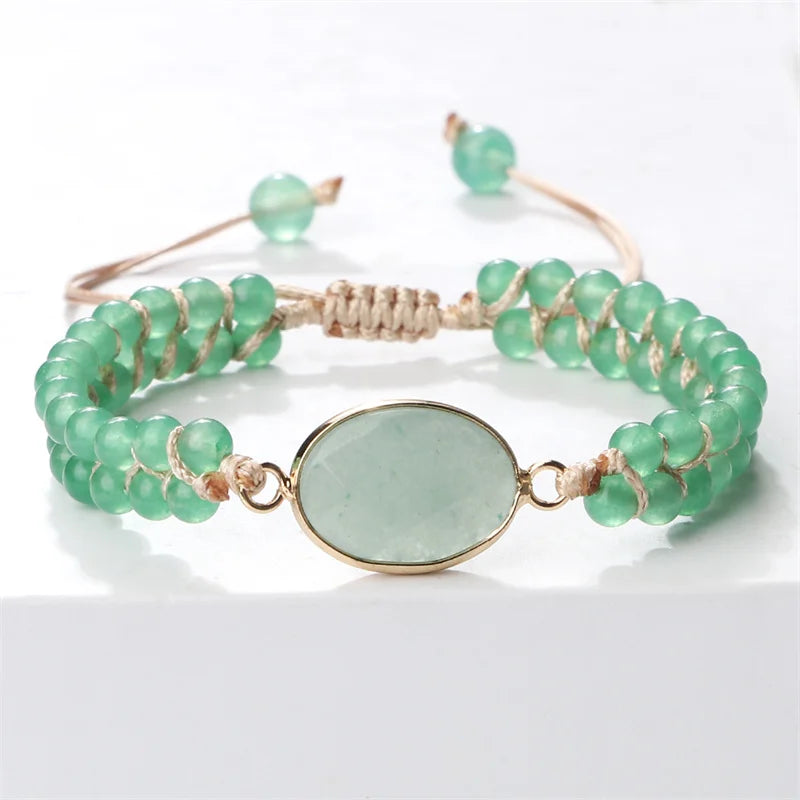 A beaded stretch bracelet featuring light green faceted beads, a central oval light green stone in a gold-toned bezel, and a natural fiber wrap closure.
