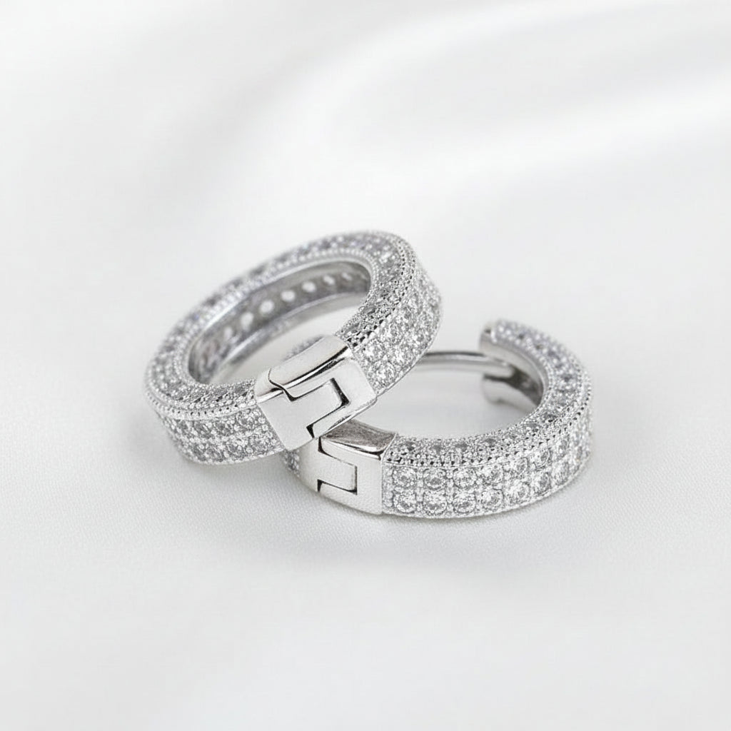 Two silver-toned huggie rings paved with clear cubic zirconia stones, 