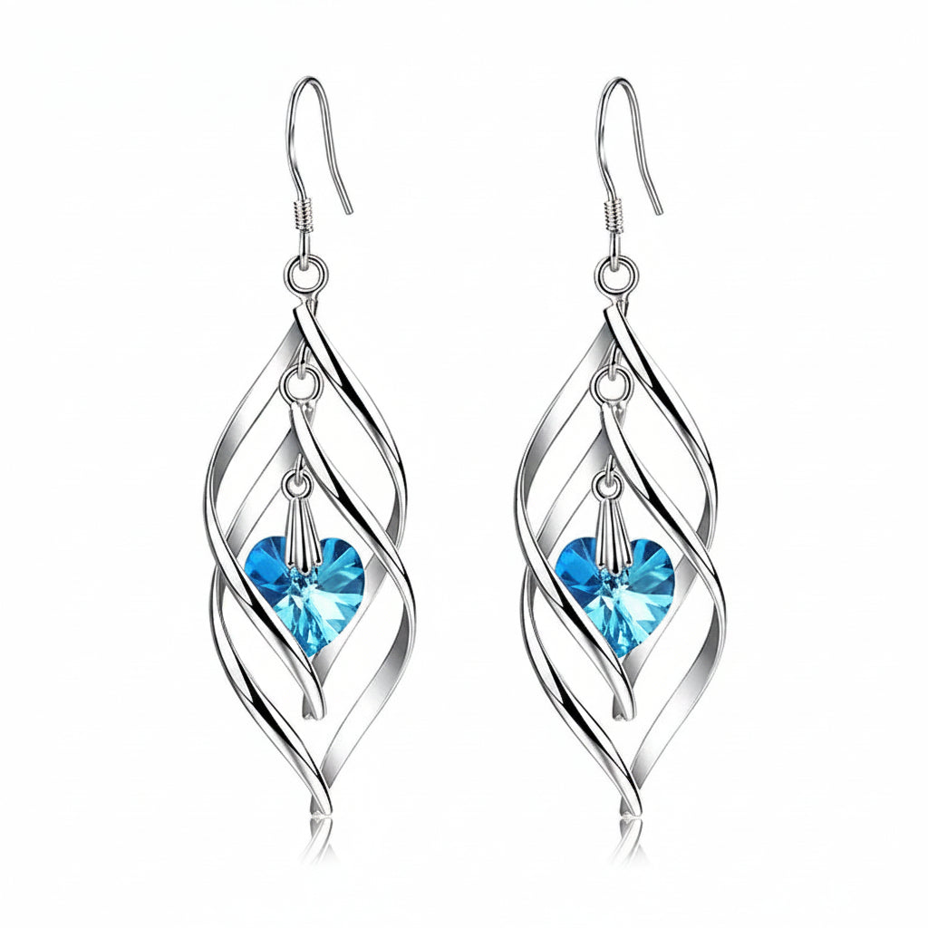 Silver earrings with blue heart-shaped gemstones on a white background