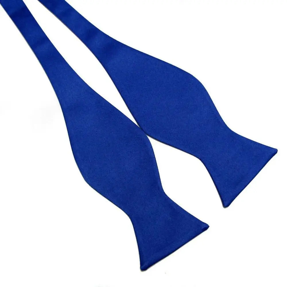 A single royal blue bow tie laid flat on a plain white background.
