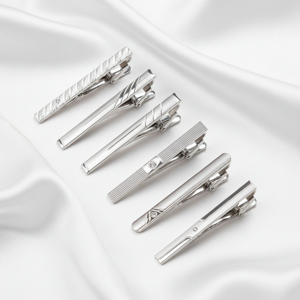Set of silver tie clips on a white background