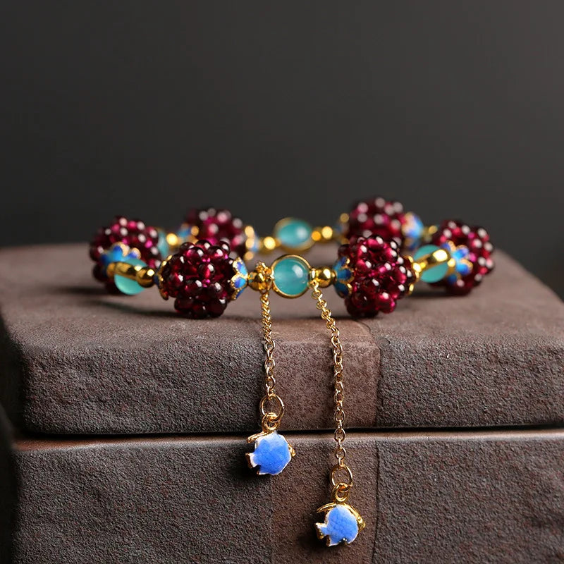 Colorful beaded bracelet with gold chain on a dark surface
