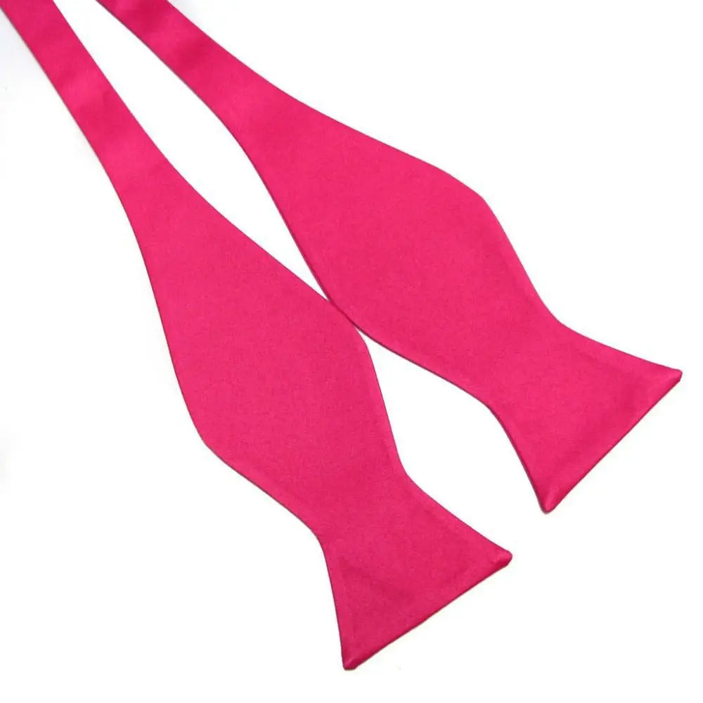 A bright pink pre-tied bow tie on a plain white background.
