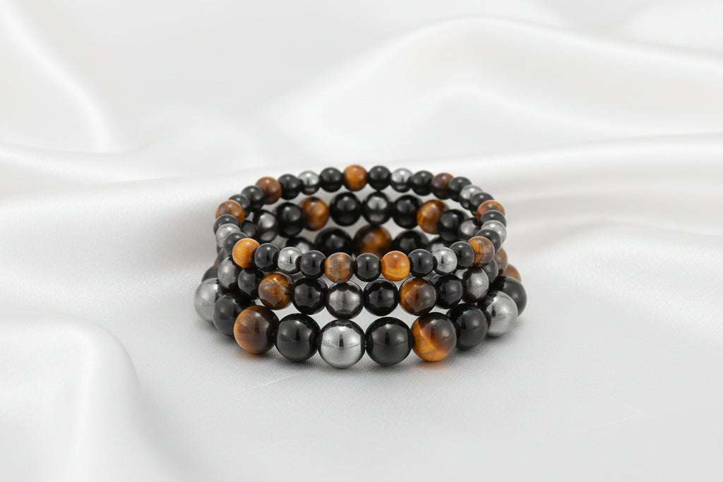 Stack of beaded bracelets with black, orange, and gray beads on a white background
