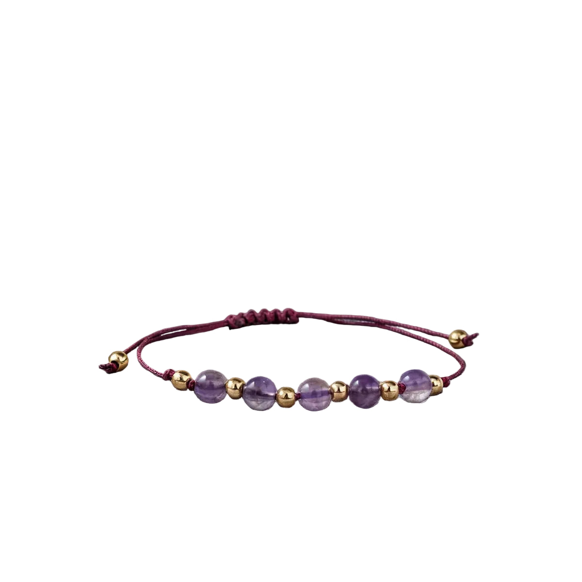 Bracelet with purple and gold beads on a dark fabric background