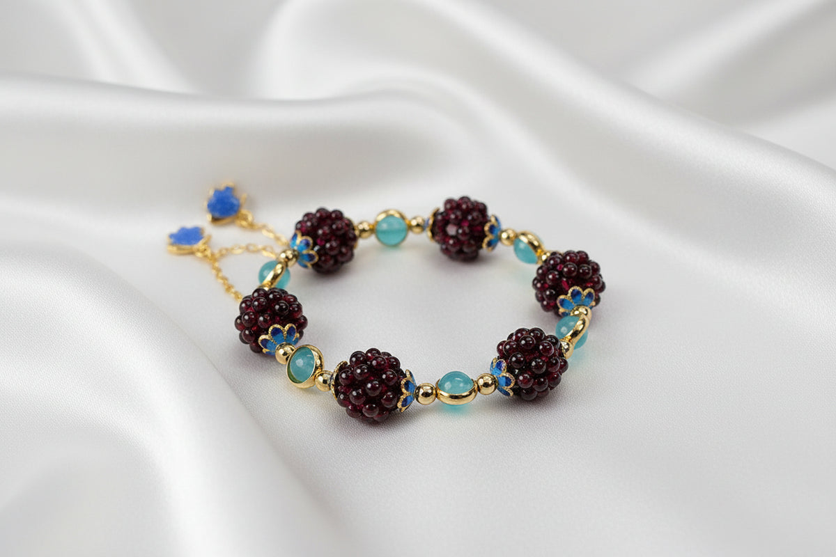 Bracelet with maroon and blue beads on a white silky background