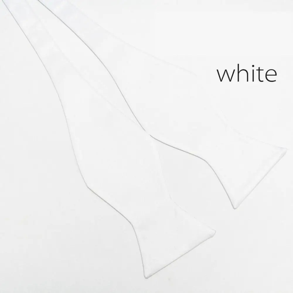 A pair of white bow ties laid flat on a white background, with the word 'white' printed in the upper right corner.