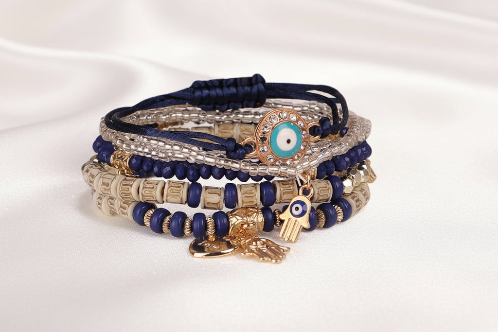 Stack of blue and gold beaded bracelets with eye charms on a white background