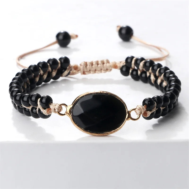 Black beaded bracelet with a gold clasp on a white background