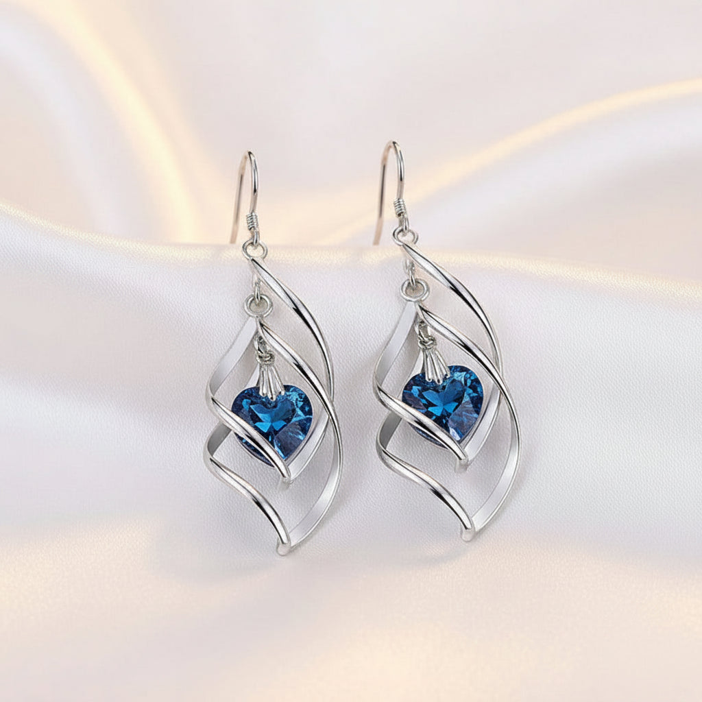 Silver earrings with blue gemstones on a white background