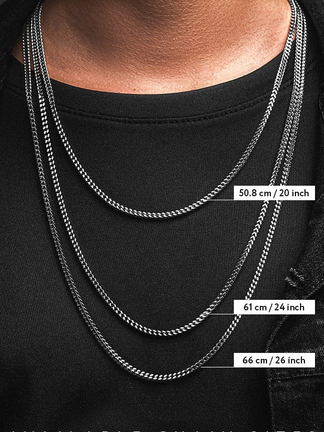 man wearing black sweater and three silver chains