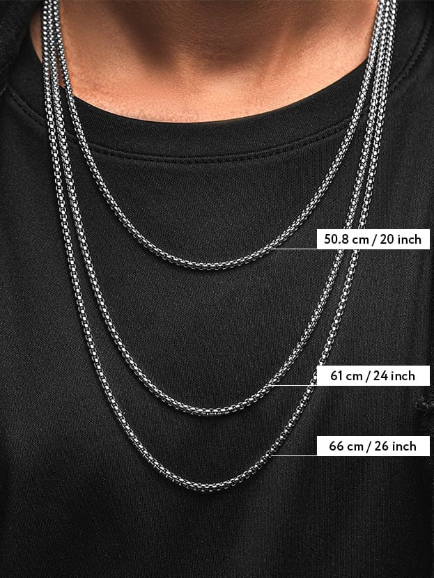 Silver chain necklace displayed on a black shirt with measurements .