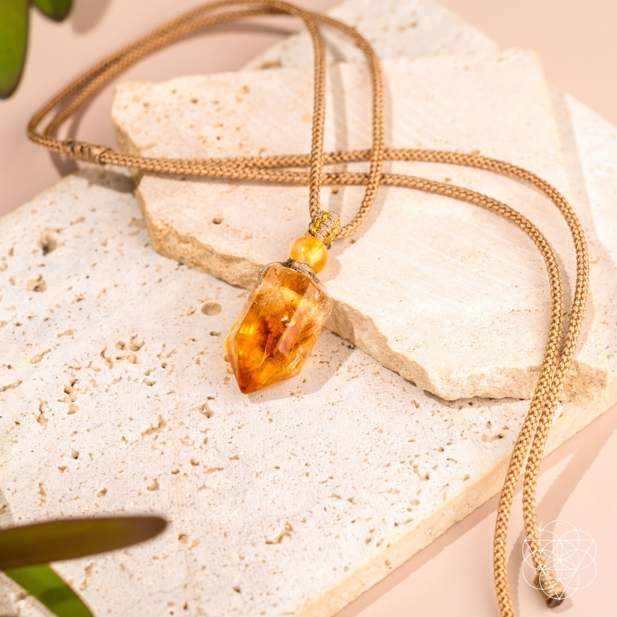 Gold necklace with a amber pendant on a textured surface