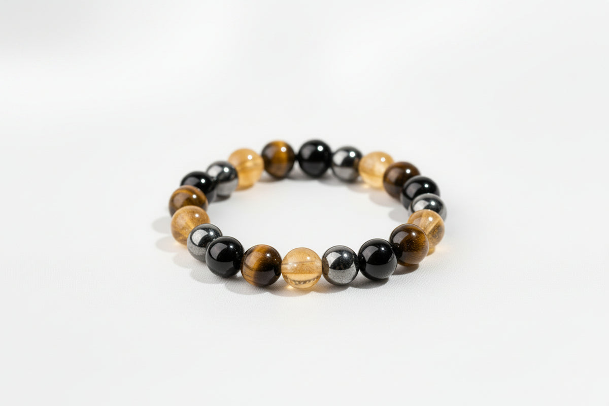 A beaded stretch bracelet made of alternating polished black and golden-yellow round beads, displayed on a white background.